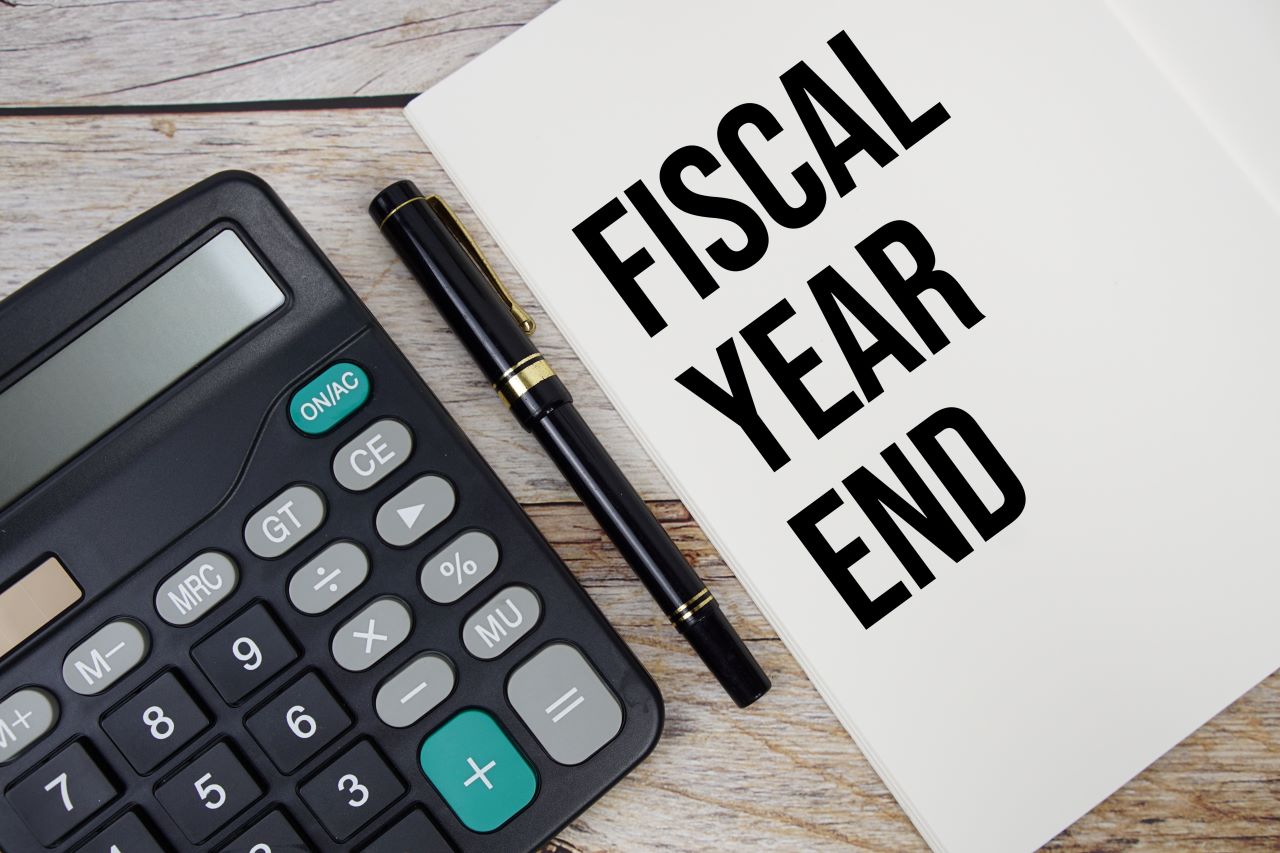 AdobeStock_898822800 Website Image of a calculator beside a pen and paper. The paper reads fiscal year end.